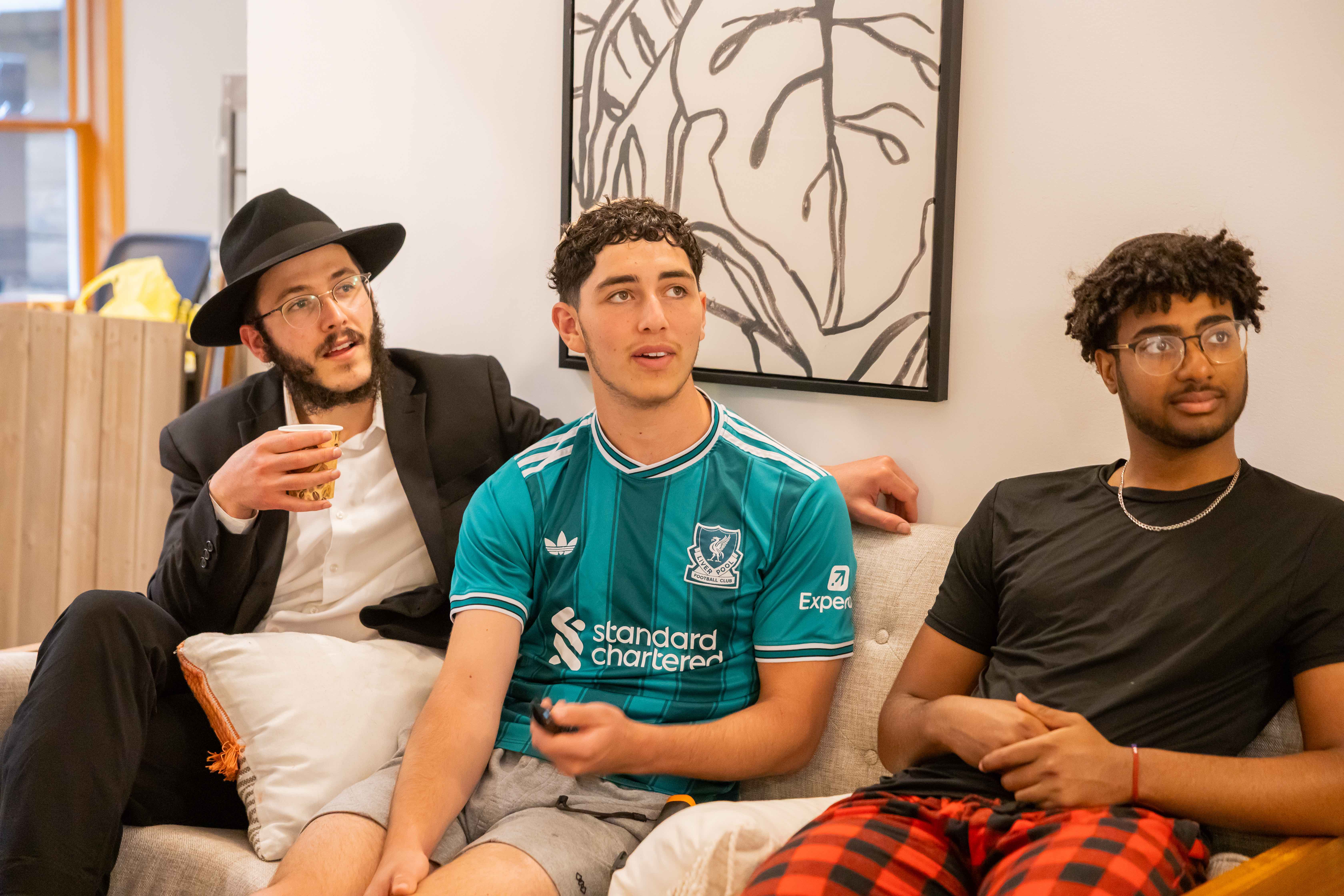 Three young men in casual conversation on couch